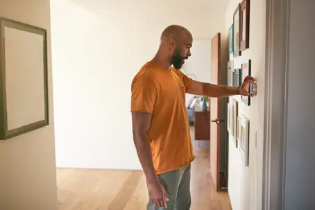person setting up thermostat