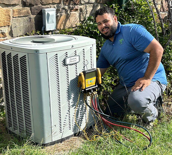 A man kneeling next to an air conditioning unit with diagnostic tools.
